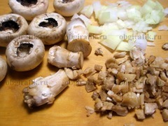 2. От грибов аккуратно отрывают ножки, которые мелко рубят. Также нарезают луковицу.