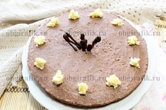 7. Украсив пирамидками белого крема и шоколадными осколками, бисквитный торт ставят на 1 час в холодильник.