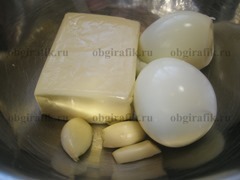 2. Подготавливают отваренные вкрутую, очищенные от скорлупы яйца, плавленный сыр, и чесночные зубья.